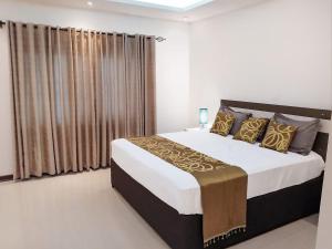 a bedroom with a large bed with gold pillows at Better value stay in Lusaka