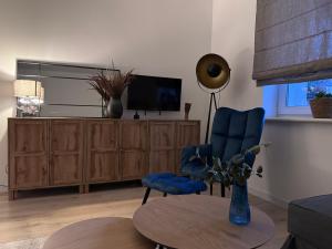 a living room with a tv and a blue chair and a table at Helenka Loft House 24H - Zabrze blisko A1, Arena Gliwice 15 min in Zabrze
