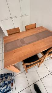 Una mesa de madera con dos sillas en el suelo en Marlin Home, en Ipsach