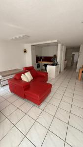 un sofá rojo en la sala de estar con cocina en Marlin Home, en Ipsach