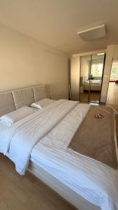 Una cama grande blanca en un dormitorio con espejo en Marlin Home, en Ipsach