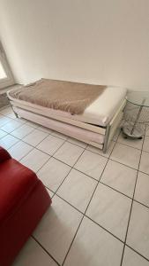 Una cama colocada sobre un suelo de baldosas en una habitación. en Marlin Home, en Ipsach