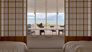 een kamer met een tafel en uitzicht op de oceaan bij Cliff House MORAI 2 