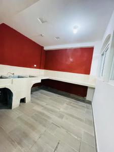 een kamer met een wastafel en een rode muur bij El rincón de Rosa in Quetzaltenango