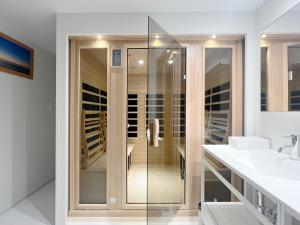 een glazen douche in een badkamer met een wastafel bij Cliff House MORAI 2 