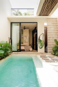 a swimming pool in front of a house at Yugen Villas in Uluwatu