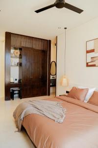 a bedroom with a bed and a ceiling fan at Yugen Villas in Uluwatu