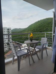 un tavolo e sedie su un balcone con vista di Moderno Apartamento con Aire Acondicionado - WIFI - Piscina - Aqualina Green - 6 Huéspedes a Girardot
