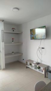 un soggiorno con tavolo e TV a parete di Moderno Apartamento con Aire Acondicionado - WIFI - Piscina - Aqualina Green - 6 Huéspedes a Girardot
