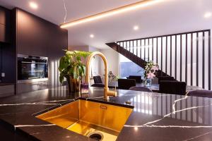 a kitchen with a sink and a living room at Modern Luxury In New Plymouth - relax and explore in New Plymouth