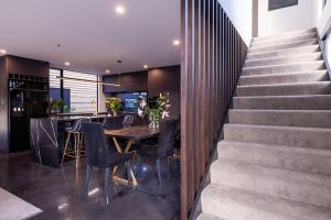 a dining room and kitchen with a table and stairs at Modern Luxury In New Plymouth - relax and explore in New Plymouth