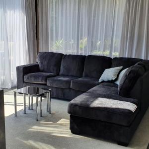 a living room with a black couch and a table at Modern Luxury In New Plymouth - relax and explore in New Plymouth +12 photos