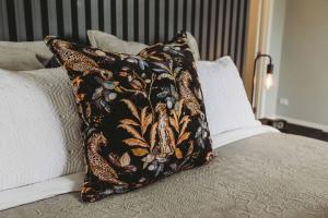 a pillow sitting on top of a bed at Buller Noire - luxury New Plymouth oceanview home in New Plymouth