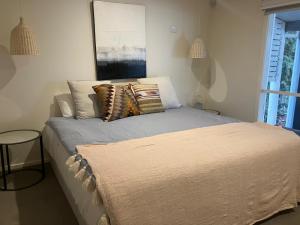 une chambre avec un lit avec des oreillers dessus dans l'établissement Bundalong River Retreat & Poolside Bliss, à Bundalong 12 autres photos