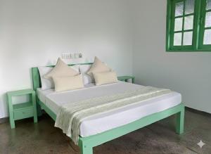 a bed with pillows on it in a room at Rella Dream in Matara