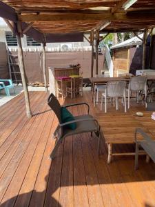 une terrasse en bois avec une table et des chaises dessus dans l'établissement Appartement spacieux à Le Lamentin, 95 m², vue mer, à Morne Vert