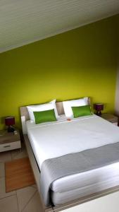 une chambre avec un grand lit avec un mur végétal dans l'établissement Appartement spacieux à Le Lamentin, 95 m², vue mer, à Morne Vert 18 autres photos