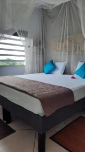 une chambre avec un grand lit avec des oreillers bleus dans l'établissement Appartement spacieux à Le Lamentin, 95 m², vue mer, à Morne Vert