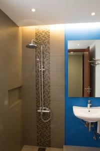 a bathroom with a shower and a sink at Karancho Beach House in Mactan