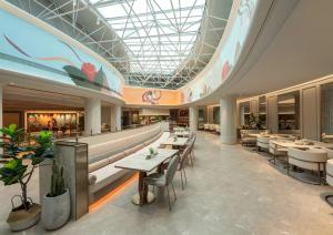 a restaurant with tables and chairs and a glass ceiling at Mercure Lanzhou Dongfanghong Square Hotel in Lanzhou +14 photos