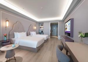 a hotel room with two beds and a flat screen tv at Mercure Lanzhou Dongfanghong Square Hotel in Lanzhou