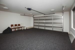a garage with two chairs and white walls at Bell Block Beauty - pristine 3BR home near beach in New Plymouth