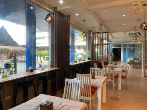 a restaurant with tables and chairs and a large window at Lalisa Hotel Aonang in Ao Nang Beach
