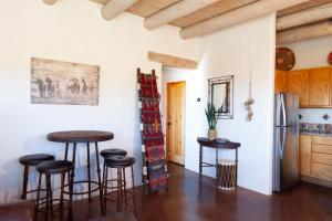 une cuisine avec une table et des tabourets dans une pièce dans l'établissement Casa de Alfarero - Hot Tub - EV Charger - Gas Grill - Mountain Views, à Arroyo Hondo