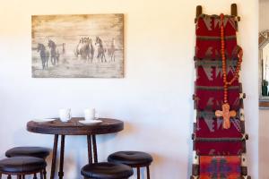 une table et des tabourets dans une pièce avec un tableau dans l'établissement Casa de Alfarero - Hot Tub - EV Charger - Gas Grill - Mountain Views, à Arroyo Hondo 25 autres photos