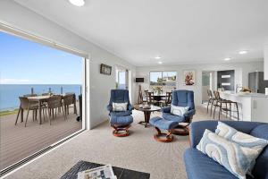 a living room with a view of the ocean at Beachfront Breeze - sea views for days in New Plymouth