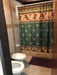 ein Badezimmer mit Toilette und Duschvorhang in der Unterkunft Casa alquiler in Ostende + 10 Fotos