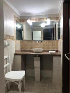 ein Badezimmer mit Waschbecken und Spiegel in der Unterkunft Casa alquiler in Ostende