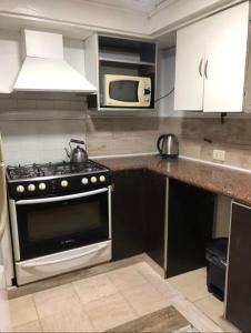 eine Küche mit Herd und Mikrowelle in der Unterkunft Casa alquiler in Ostende