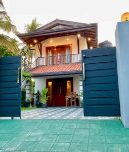 a house with blue gates in front of it at Cinnamon Luxury Villa,Beruwala,Bentota in Beruwala