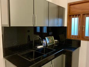 a kitchen with a sink and a black counter top at Cinnamon Luxury Villa,Beruwala,Bentota in Beruwala