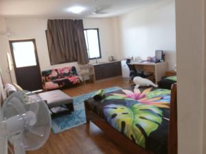 VaiteleにあるSamoa FINAU 685 Accomodationsのベッドのあるリビングルームと扇風機のある部屋