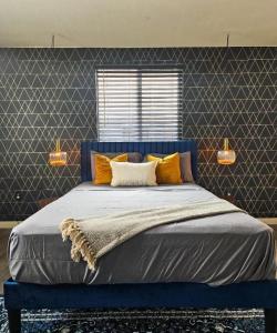 ein blaues Bett mit orangefarbenen Kissen in einem Schlafzimmer in der Unterkunft Forty First Place - Boutique Hostel in Los Angeles