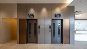 uma fila de elevadores num edifício de escritórios em Toyoko Inn Kochi em Kochi