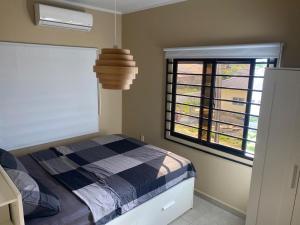 a bedroom with a bed and a large window at Sisa Omi Apartments in Wanica