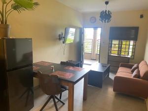 a kitchen and living room with a table and a couch at Sisa Omi Apartments in Wanica