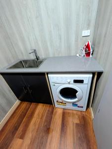 a kitchen with a sink and a washing machine at ICHA Apartments in Suva