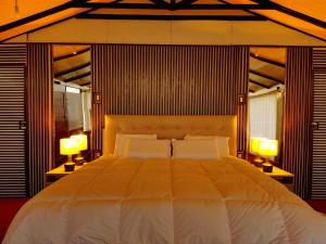 a bedroom with a large white bed with two lamps at Meytic Titicaca lodge Uros in Puno +17 photos