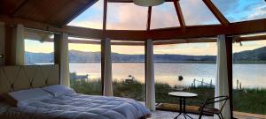 a bedroom with a bed and a view of the water at Meytic Titicaca lodge Uros in Puno