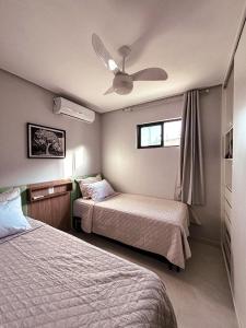 Apartamento luxo e novo com vista em Gravatá في غرافاتا: غرفة نوم بها سريرين ومروحة سقف