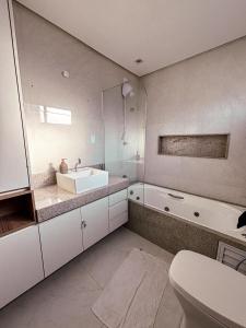 Apartamento luxo e novo com vista em Gravatá في غرافاتا: حمام مع حوض وحوض استحمام ومرحاض