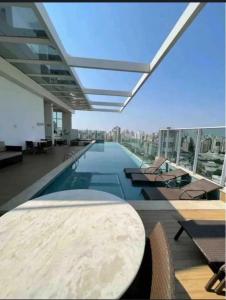 a building with a pool and a table and chairs at DNA Flat Experiência, novo e lindo, com piscina incrível in Goiânia