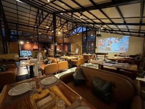 een restaurant met tafels en stoelen en een groot scherm bij Villa Himalayan Trove in Jāmb