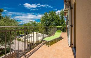 a balcony with a green chair on a patio at Apartments in Soline - Insel Krk 41809 in Soline +6 photos