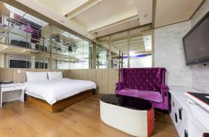 um quarto com uma cama e uma cadeira roxa em Jeonju Castle em Jeonju