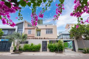 a house with pink flowers in front of it at Hoàng My Villa - 100m tới bãi tắm Long Cung in Vung Tau